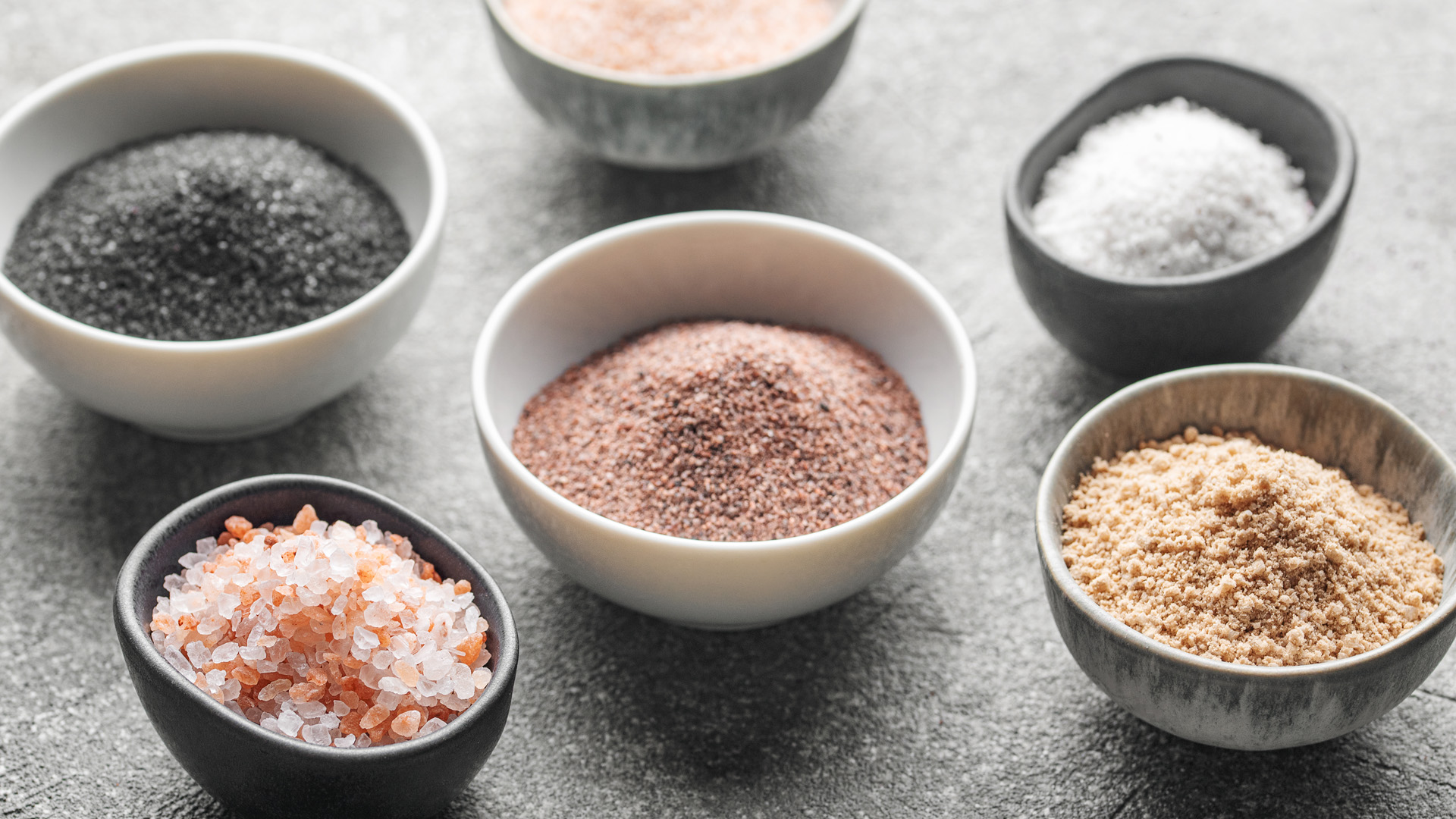 Assorted finishing salts including fleur de sel, Maldon, and Himalayan pink salt, used to elevate the flavor and texture of dishes